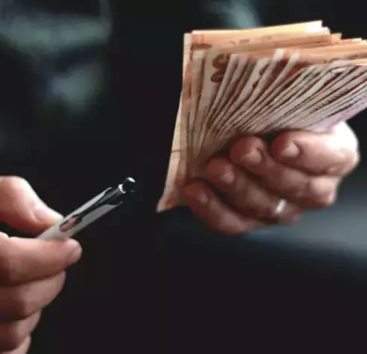 A person holding a stack of money. Description generated by AI