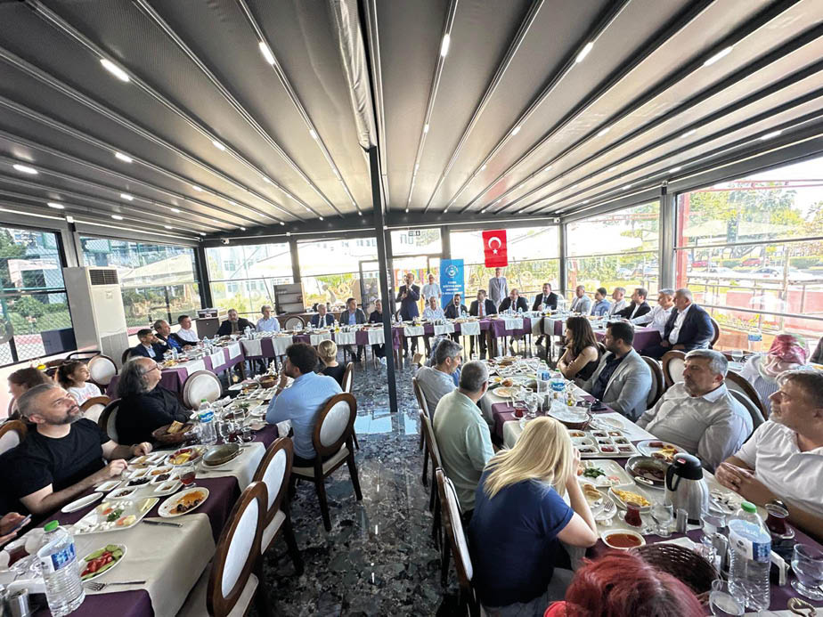 A group of people are sitting around a large dining table. Description generated by AI