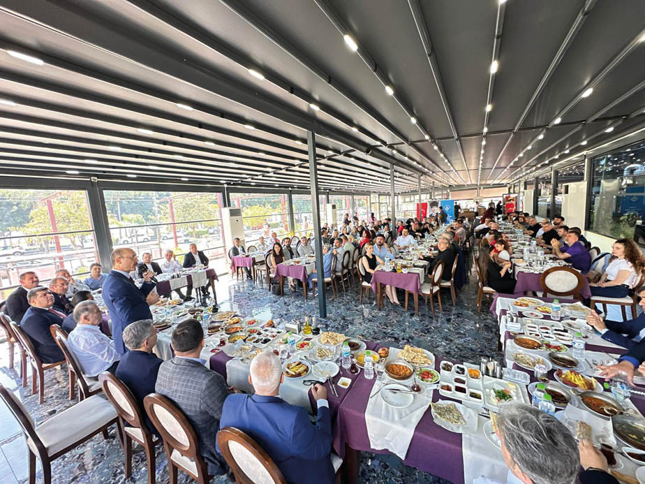 A group of people are sitting around a large dining table. Description generated by AI