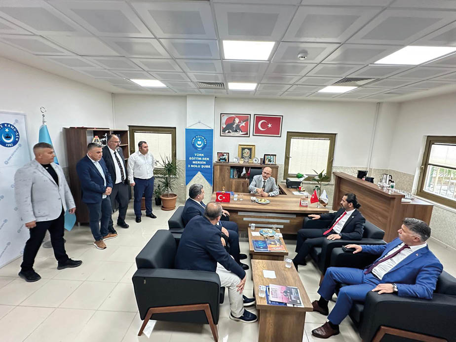 A group of men in suits are sitting around a table. Description generated by AI