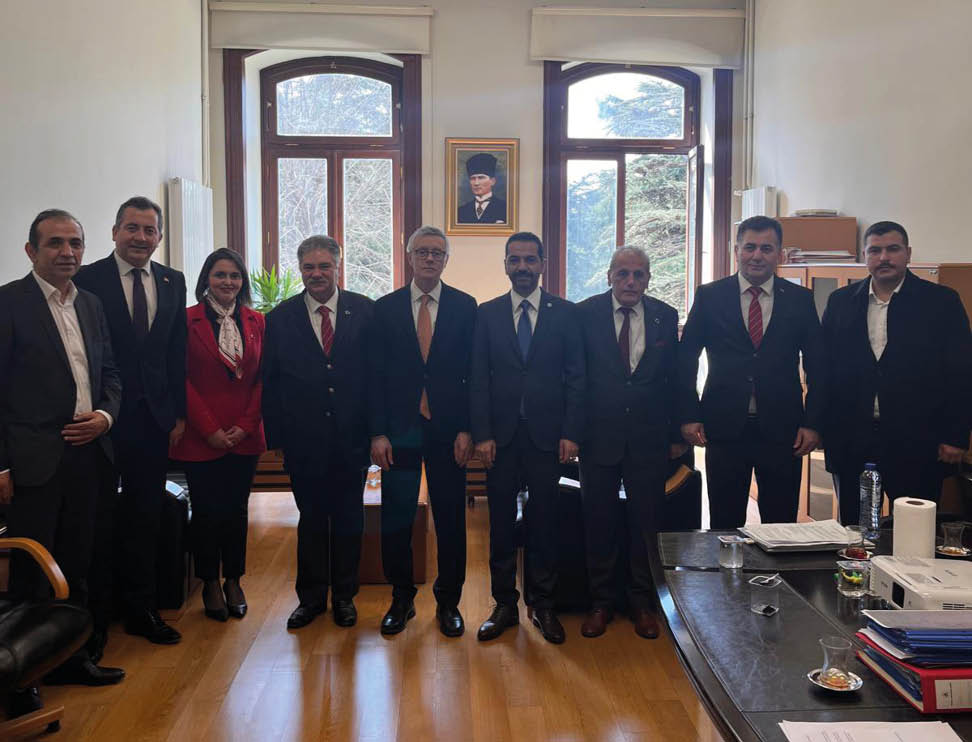 A group of men wearing suits and ties standing in a room. Description generated by AI