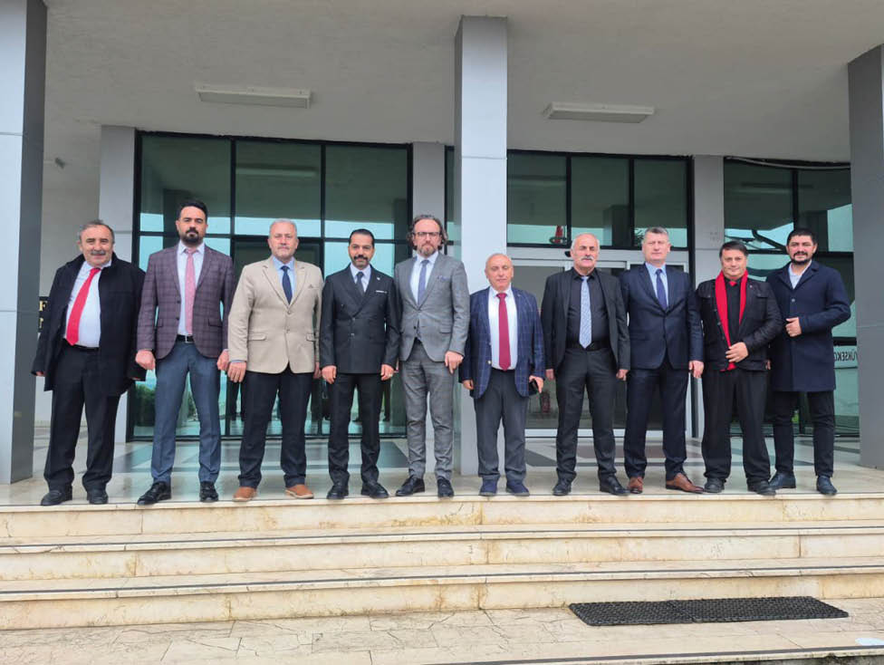 A group of people dressed in formal and semi-formal attire standing in a line on steps outside a building with large glass windows. Description generated by AI