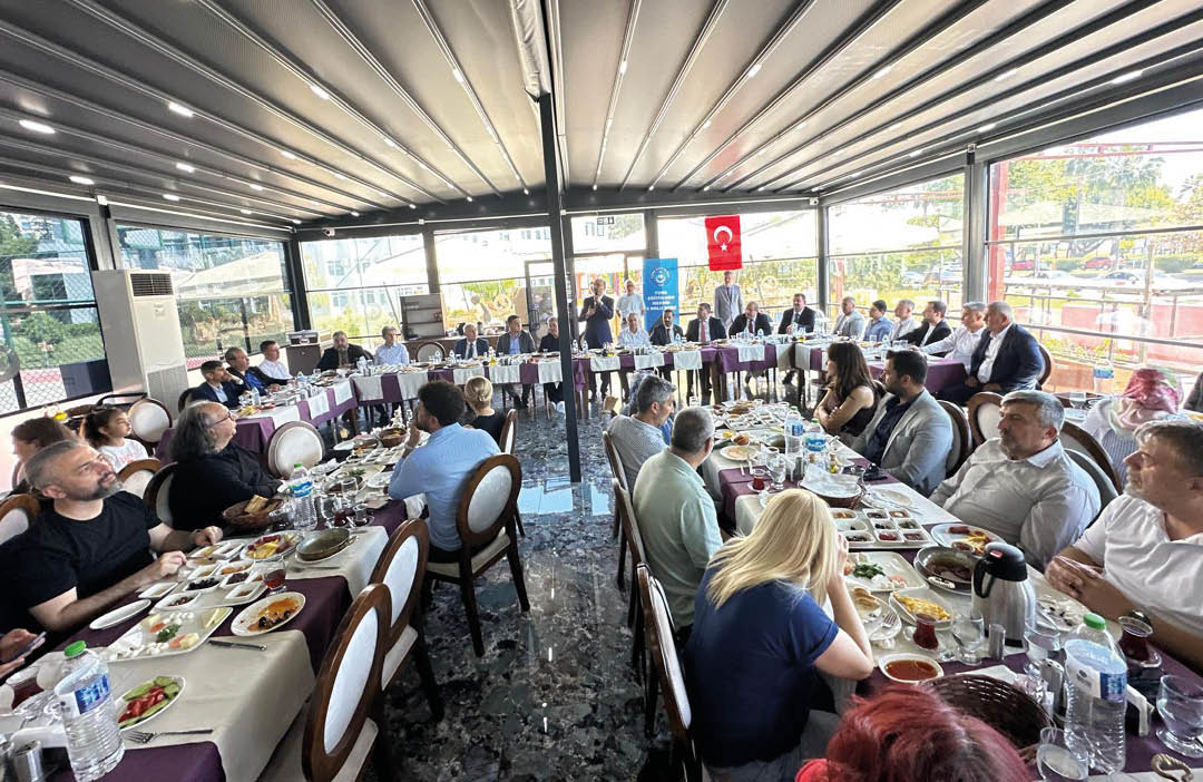 A group of people are sitting around a large dining table. Description generated by AI