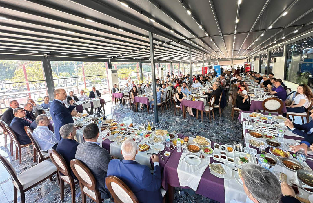 A group of people are sitting around a large dining table. Description generated by AI