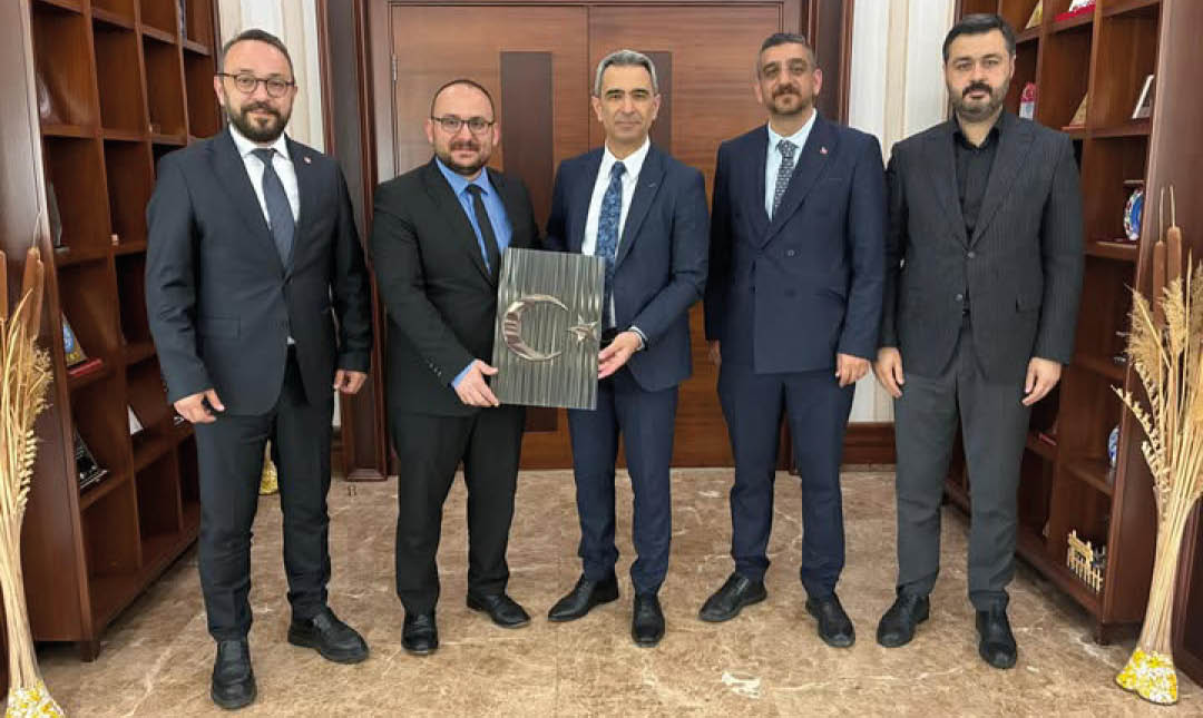 A group of men in suits holding a book. Description generated by AI