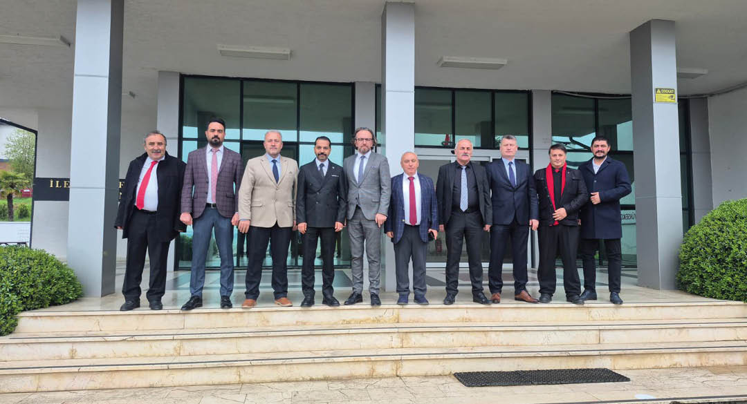 A group of people dressed in formal and semi-formal attire standing in a line on steps outside a building with large glass windows. Description generated by AI